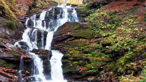 Narrow Stream Falling Down Mountain Slope in Autumn Forest