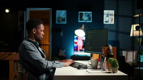 Afroamerikaner arbeitet am PC, um Code zu schreiben und zu programmieren