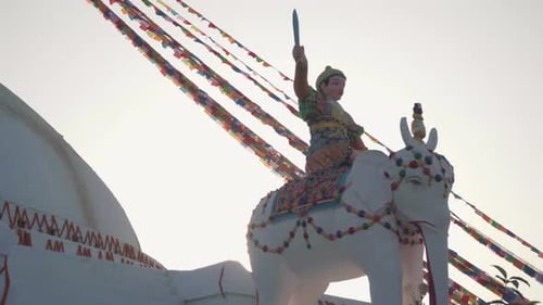 Elephant Statue With Warrior Holding A Sword In Front Of Boudhanath Stupa Against The Bright Sky. -
