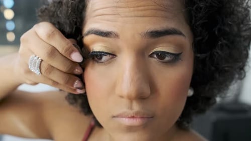 Woman Applies False Eyelashes During Makeup Routine