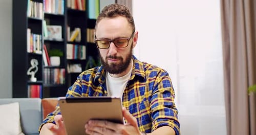 Man Using Tablet Indoors At Home Daytime