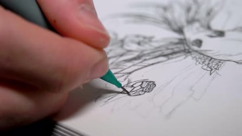Person sketching with a green pencil on a white paper. Close up shot