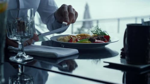 Männliche Hände benutzen serviertes Besteck und essen leckeres Abendessen in einem stilvollen Restaurant