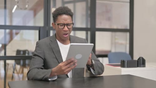 Man Shocked Using Tablet at Office Desk
