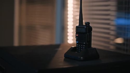 Walkie Talkie on Desk in Dark Office with Closed Window Blinds