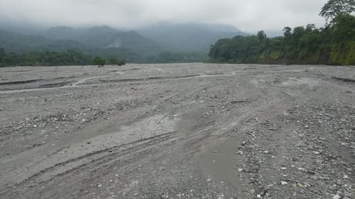 Aerial drone shot of a dried river during drought. Cars driving on a dried up river delta.