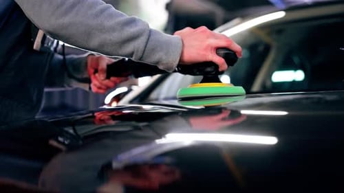 Closeup of the Hands of a Car Mechanic at a Service Station Doing the Final Polishing to Shine