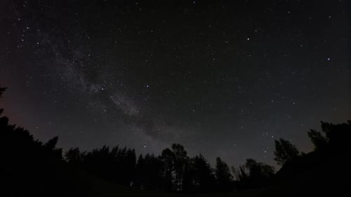 Lap de temps des étoiles, y compris la Voie lactée, se déplacent au-dessus d'une silhouette, d'une forêt, également de satellites et