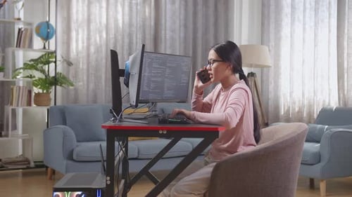 Une jeune programmeuse asiatique parle sur un smartphone tout en créant une application de développement d'une Appli d'ingénieur logiciel