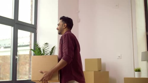 Man Carrying Box in Bright Room