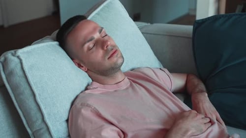 Calm Relaxed Caucasian Young Man Resting Napping on Sofa with Eyes Closed at Home Happy Healthy Guy