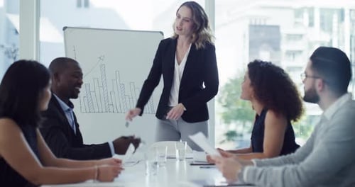 4k video footage of a young businesswoman giving a presentation to her colleagues in an office