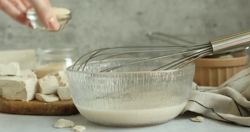 Baking ingredients being added to clear bowl
