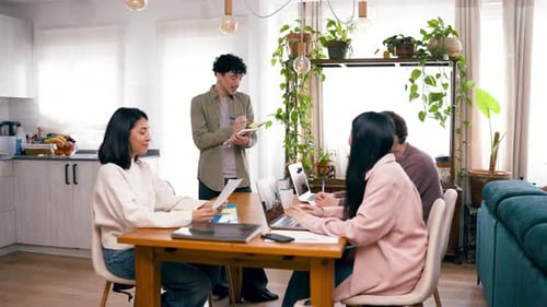 Business Team Collaborating at Table With Laptops and Documents