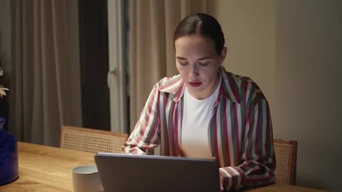 Woman Using Laptop at Table Indoors
