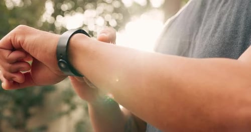 Man Looks at Fitness Tracker on Wrist