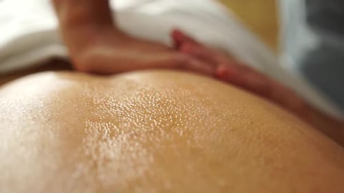 Close up massage therapy hands giving health to a beatiful woman relax in spa. Massage hands process