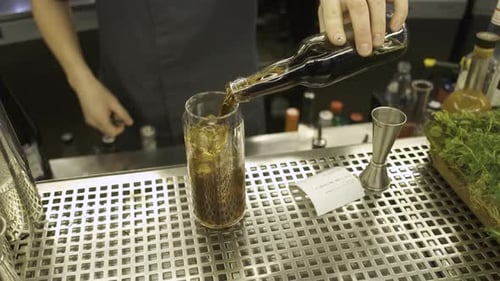 close-up bartender pours cola into a glass