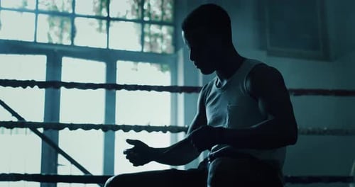 Cinematic slow motion shot of a professional young muscular african man is wrapping black bandages