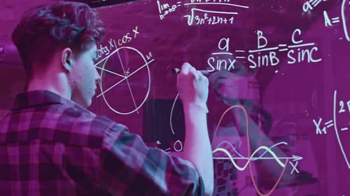 Young Man Solves Mathematical Equations on Blackboard Media Young Man Solves Complex Equations on