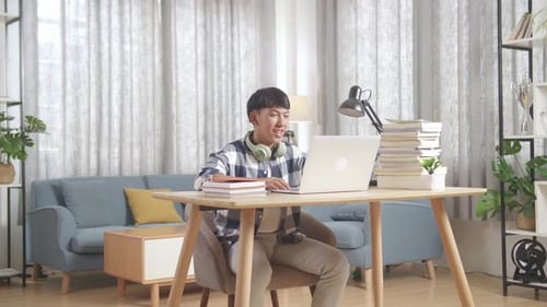 Young Adult Using Laptop for Distance Learning