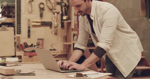 4k video footage of a handsome young male carpenter working in his woodworking workshop