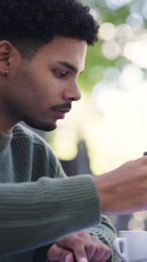 Young Black Male Student Writing in a Notebook on Campus Outdoors Vertical
