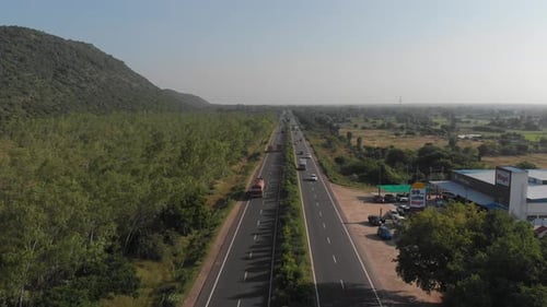 Hovering over the center line of a highway in rural India with traffic going by