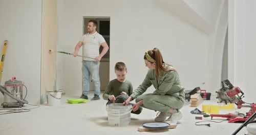 Family Painting Wall Together During Home Renovation