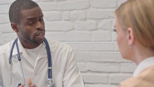 Doctor Consults with Patient in Clinic Office