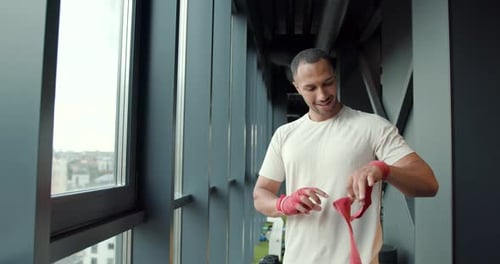 Latin Man Putting on Boxing Bandages on Wrists