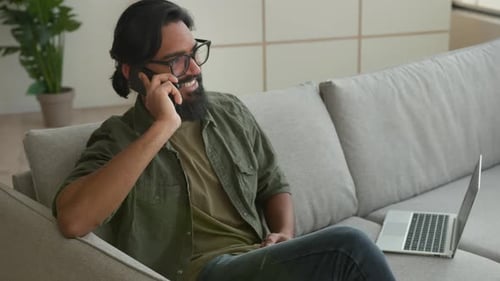 Man Talking on Phone While Relaxing on Sofa