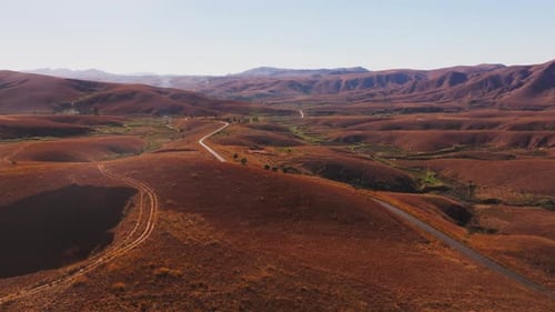 Aerial View of a Winding Road Crossing the Arid Highlands of Madagascar The Red Soil and Sparse
