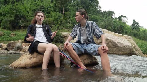 Young Couple Relaxing by Forest River