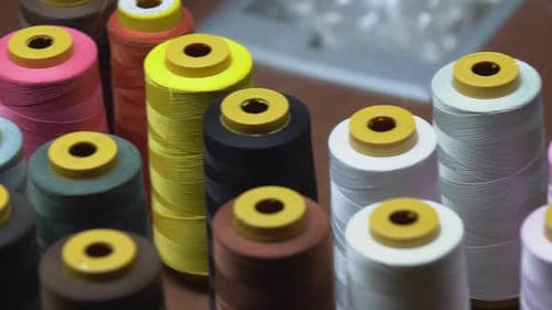 Panning Shot Of Colourful Spools Of Cotton Thread In A Clothing Manufacturing Workshop