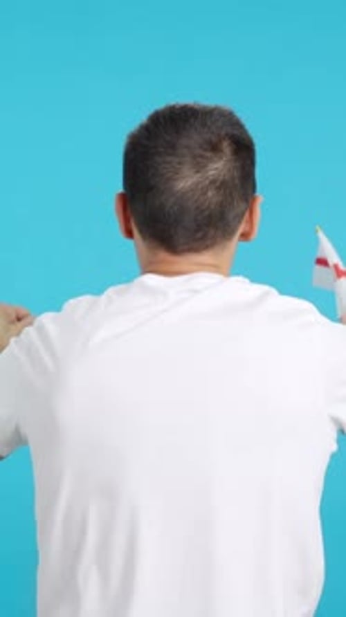 Rear View of a Man Waving a English Pennant