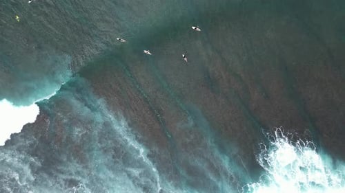Top-down drone shot of surfers in the ocean