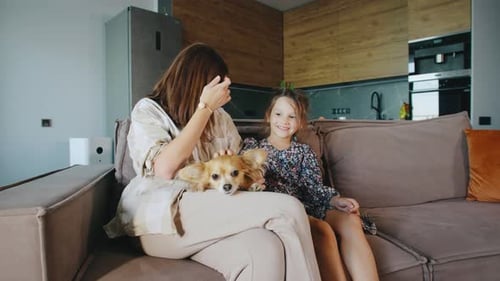 Woman and Girl Petting Chihuahua on Couch