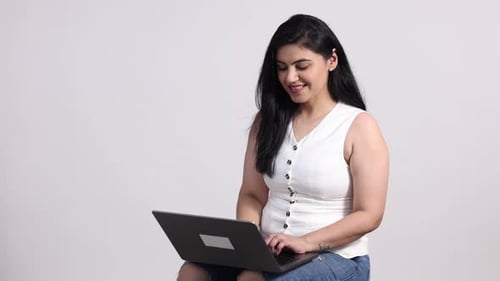 Excited young woman working on laptop celebrates success