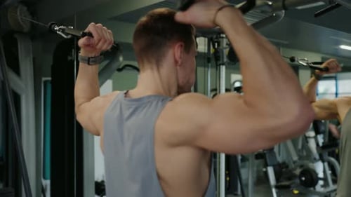 Young Male Athlete Training Back Muscles in Modern Gym