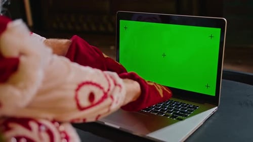 Closeup of Santa Claus Hands Typing on Laptop