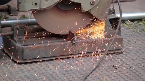 Handwerker, der Eisen mit einer Kreissägemaschine im Freien schneidet, Nahaufnahme, Zeitlupe.