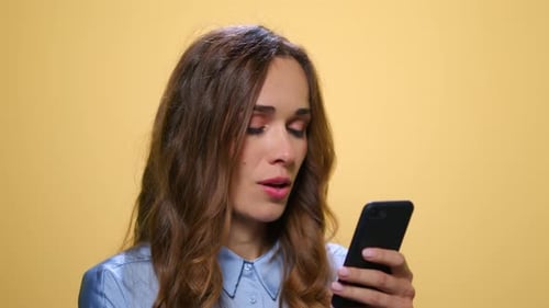 Attractive woman using smartphone in studio setting