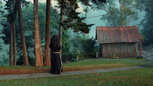 Religious Christian Catholic Franciscan friar meditating or praying by the woods