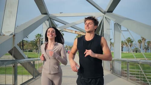 Cheerful Couple Jogging Together on a Sunny Day in a Picturesque Park Surrounded By Palm Trees