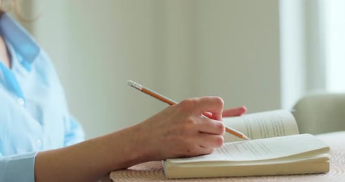 Closeup Woman Student Preparing Her Lessons at an Office Table The Girl Reads and Studies From an