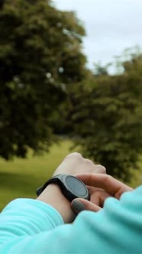 Vertikale Darstellung einer Läuferin mit Smartwatch-Fitness-Tracker