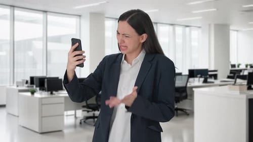 Businesswoman Video Calling on Smartphone in Modern Office