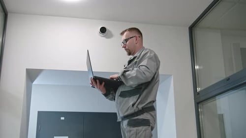Hombre con gafas revisa las cámaras de CCTV en un programa de computadora