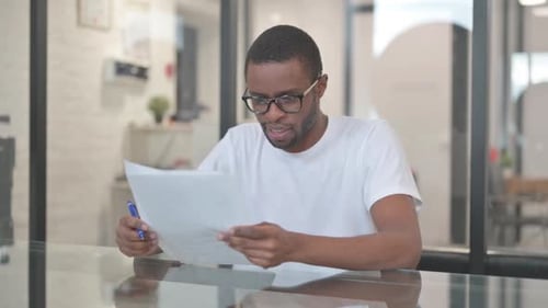 Young Adult Reading Documents in the Office